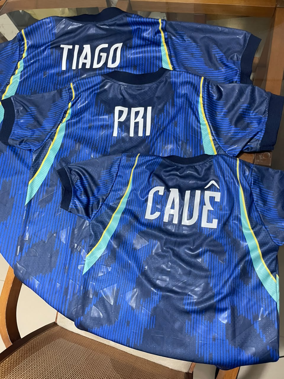 Camisetas azuis personalizadas com os nomes Tiago, Pri e Cauê